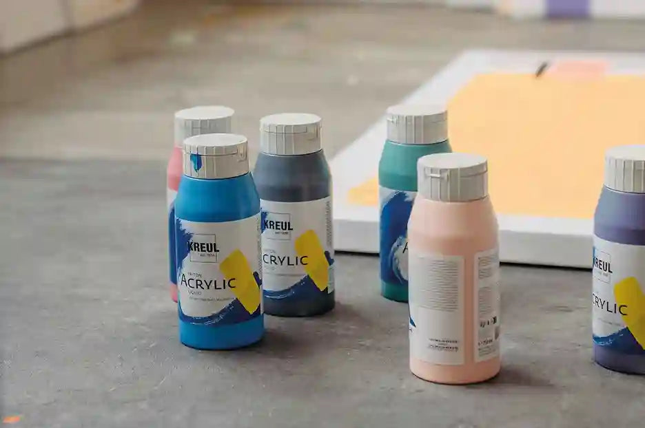 Close‑up of KREUL Triton Acrylic Liquid bottles showing flowing acrylic paint in bright colors.