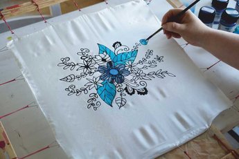 Hand painting a blue floral design on white silk fabric using KREUL Javana silk paints