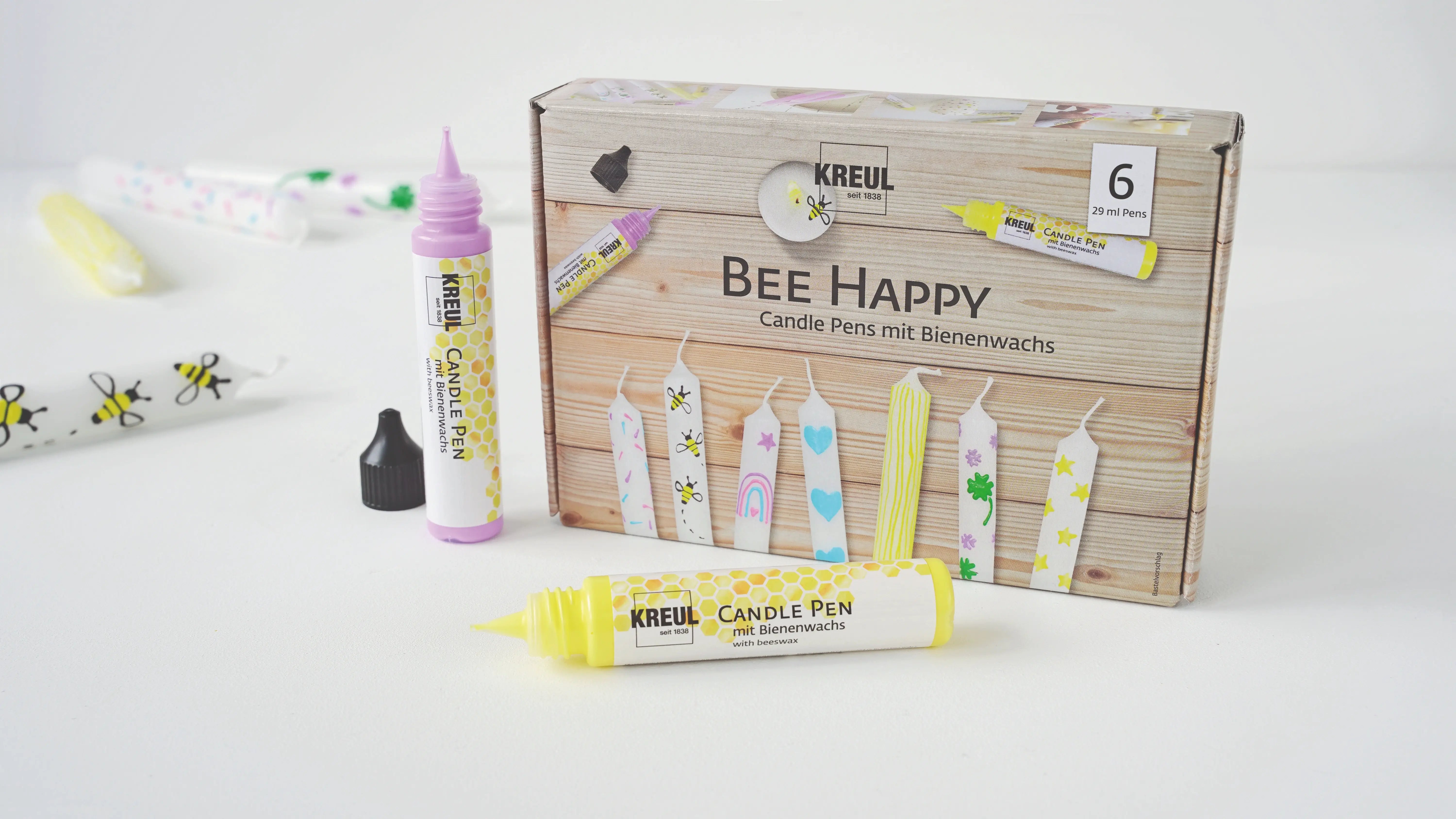 Decorating a candle with KREUL Bee Happy candle pen in pastel colours