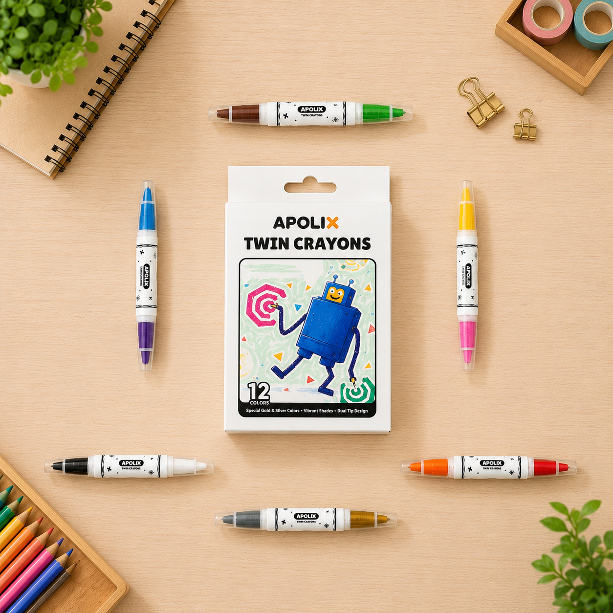 A set of 12 APOLIX twin crayon markers arranged on a light wood desk with school supplies. The center shows the white product box with a blue robot illustration, surrounded by the individual markers in various colors including blue, purple, brown, yellow, pink, orange, gray, and gold.